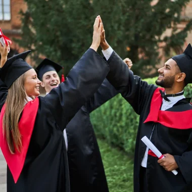 three-happy-international-graduate-friends-greeting-university-campus-graduation-robes-with-diploma